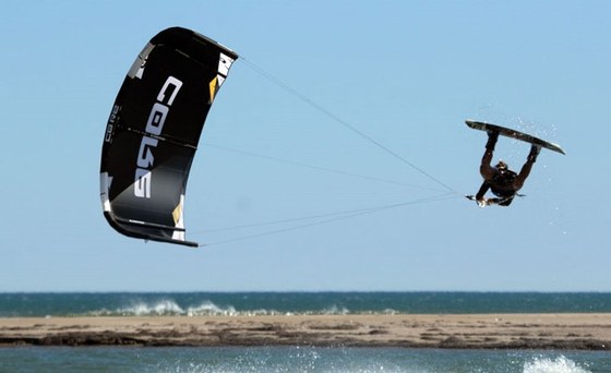 A rider doing a freestyle trick with a Core kite above flat water