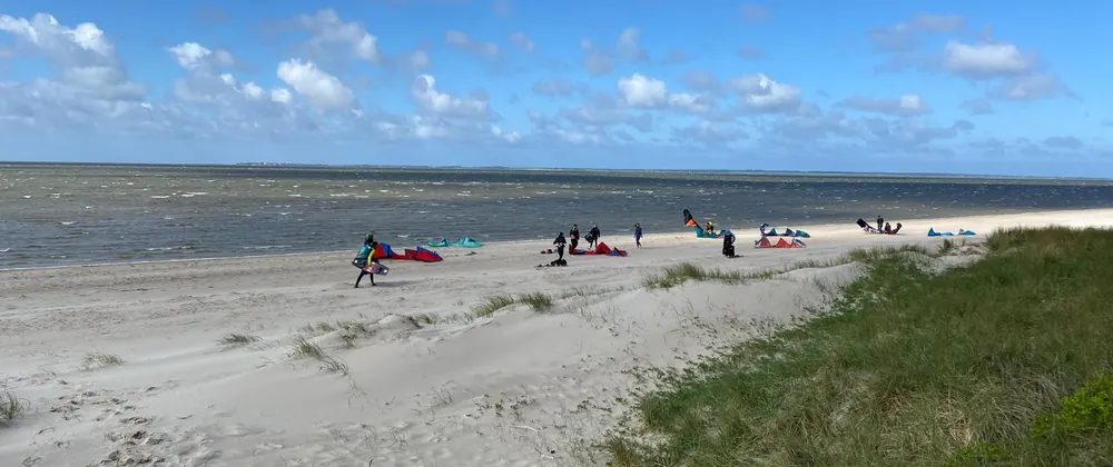 Kiters rigging their kites on the beach at Nieblum under a blue sky